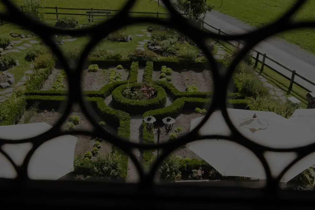 Blick durch das Fenstergitter auf den Ziergarten