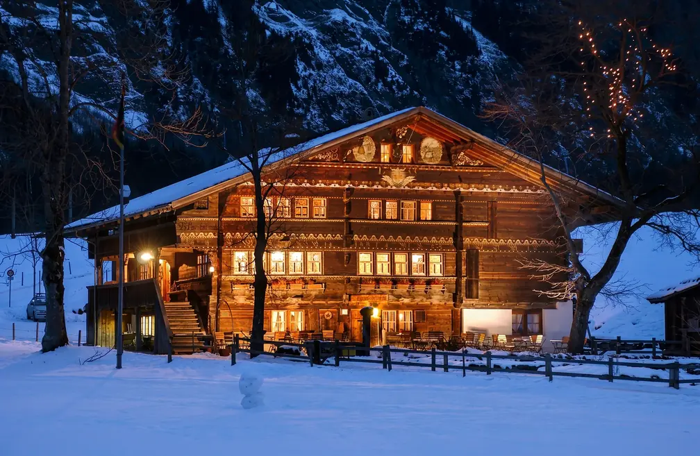 Das Haus im Schnee zur blauen Stunde, alle Fenster erleuchtet