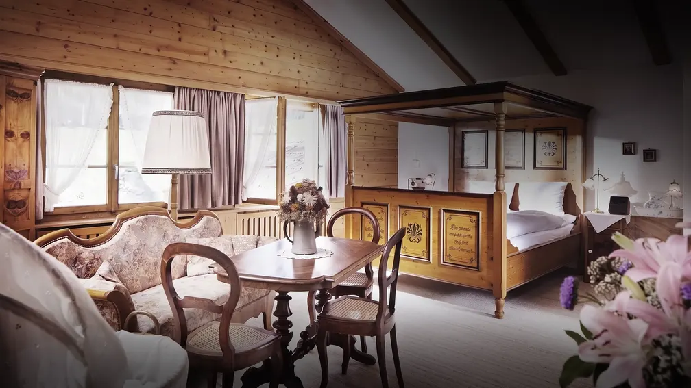 Salonzimmer mit Himmelbett, Tisch und Sofa