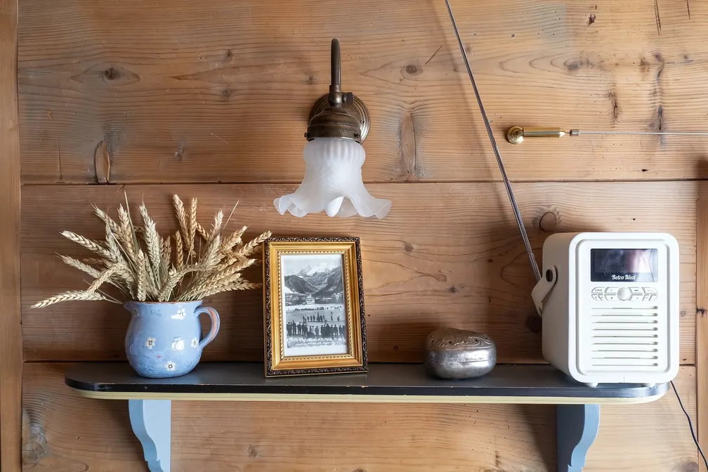 Wandbrett mit Lampe, Ähren und Radio in der Liebeslaube