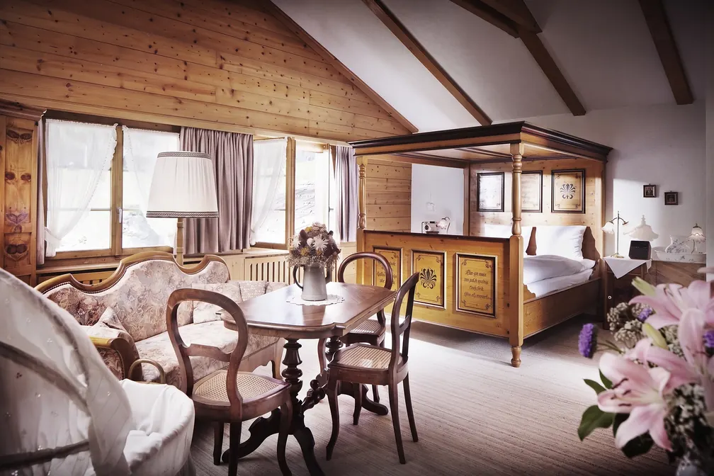 Salonzimmer mit Himmelbett, Tisch und Sofa
