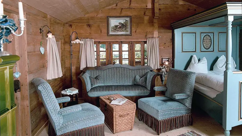 Zimmer mit blaugrauem Sofa und Himmelbett